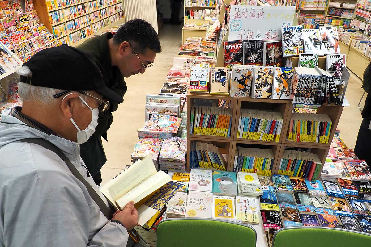 書店に並ぶ本をのぞき込む人たち＝釜石市大町・桑畑書店