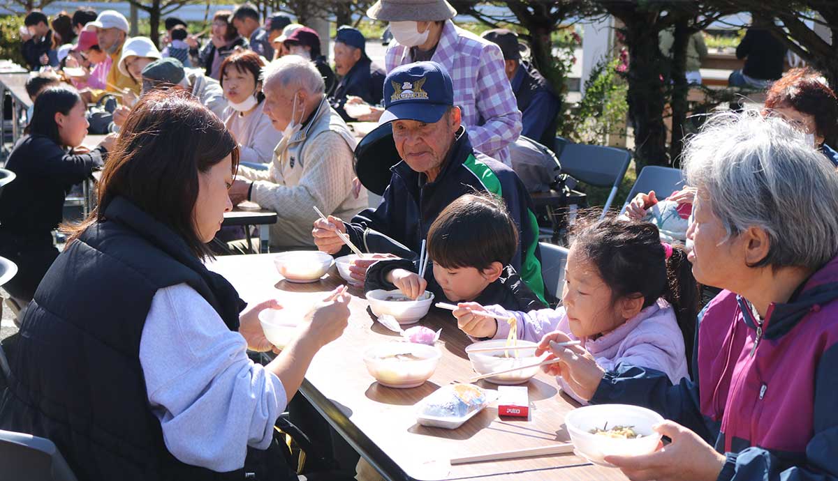 青空の下で食事を楽しむ来場者