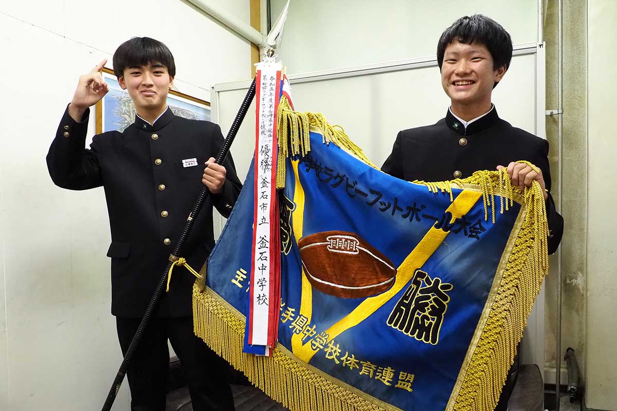 優勝旗を掲げて笑顔を見せる佐藤碧空さん（左）と山崎陽介さん