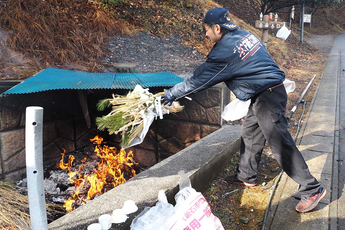 地域の消防団員が飾りを受け取り、分別して火に投じた