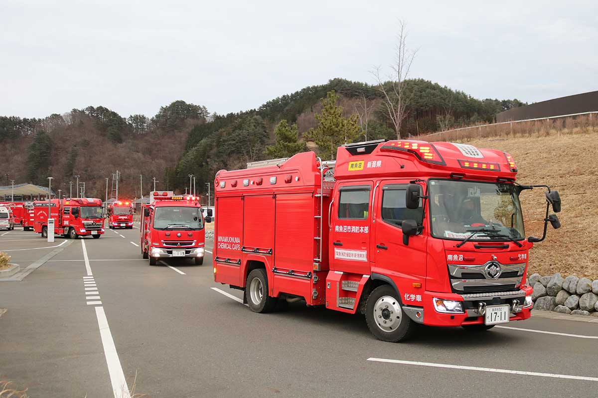 市民体育館を出発する新潟県隊の消防車両