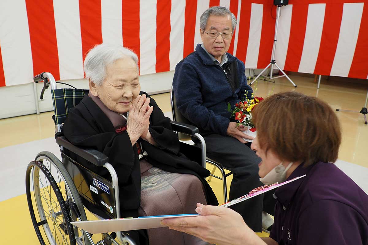 デイサービス担当の職員からの贈り物に感謝する盛さん
