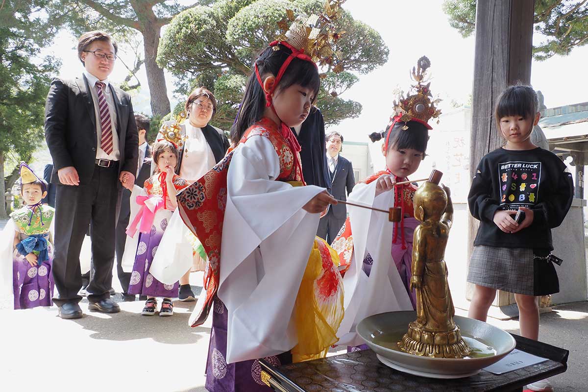 稚児行列に参加し、釈迦像にひしゃくで甘茶をかける子ども