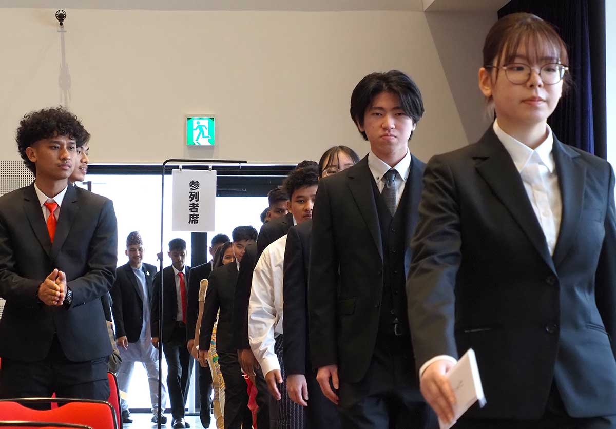 在校生や教職員らの拍手を受けながら入場する新入生