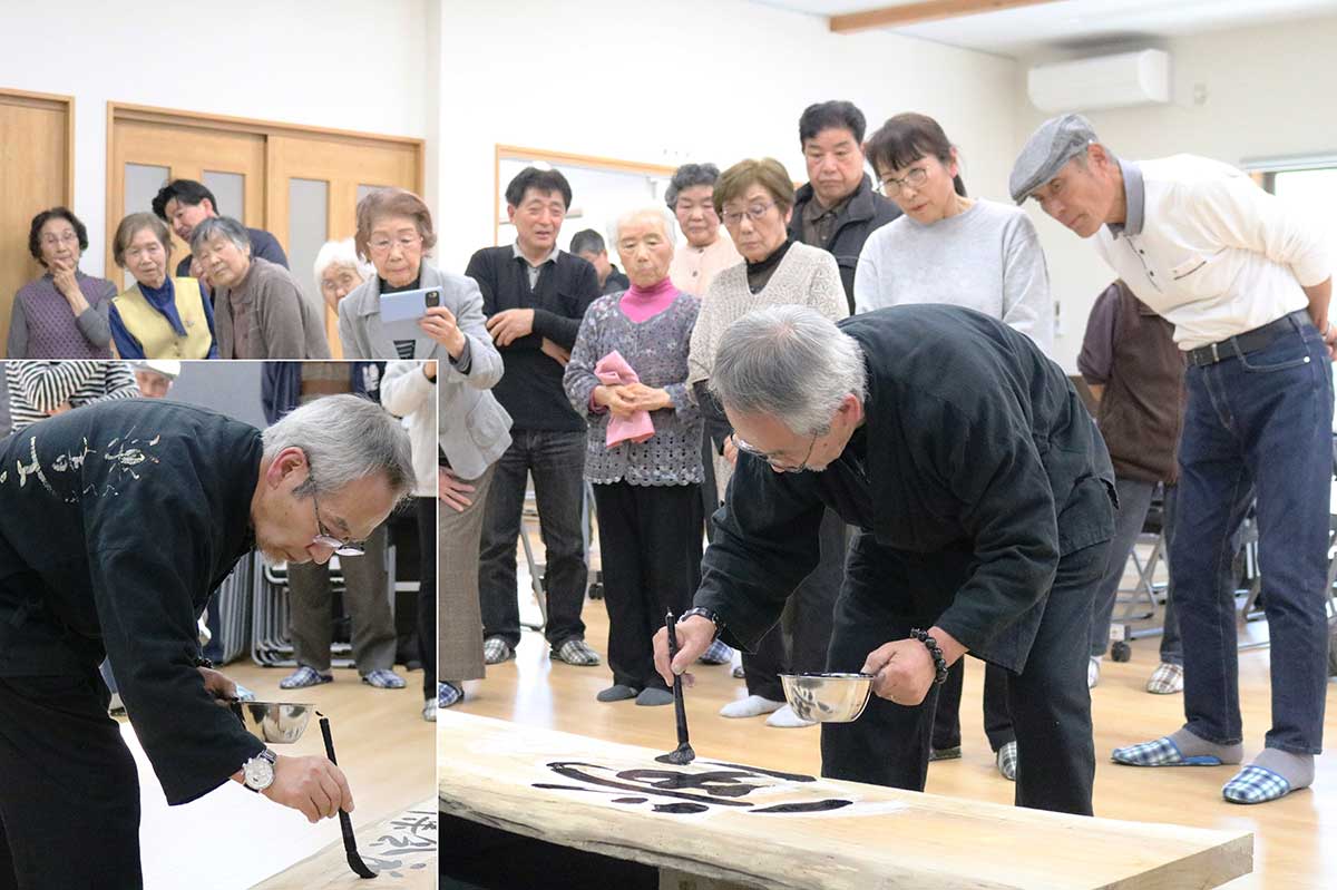 支部蘭蹊さんが集会所に掲げる看板を揮毫。「蛍の里」もアピール