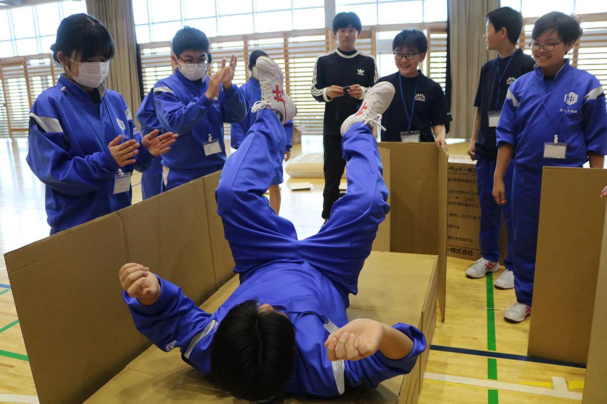 避難所開設時に使う段ボールベッドを組み立て、寝心地を確かめる＝釜石東中防災オリエンテーション