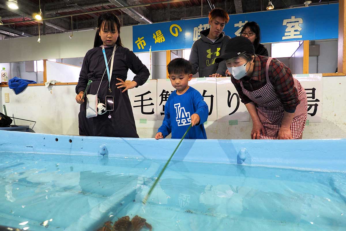 毛ガニ釣りに挑む子どもたちに周囲の大人が声援を送る