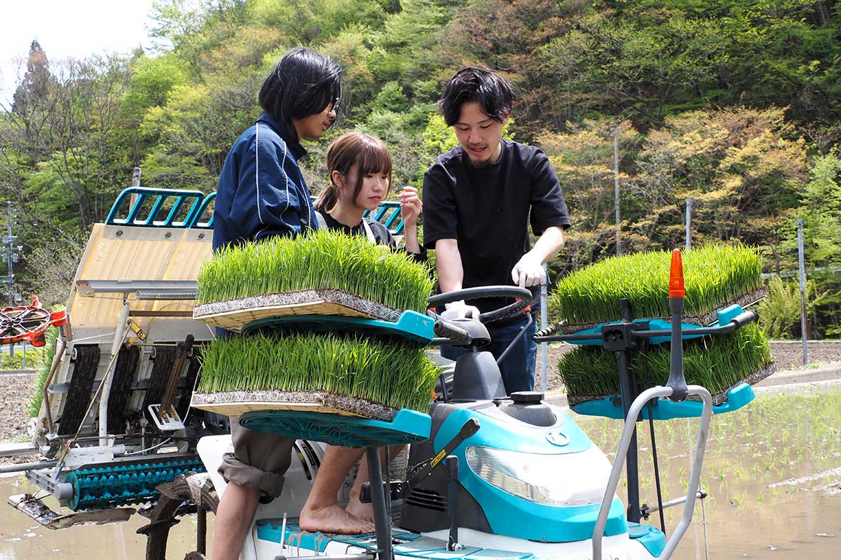 田植え機の操縦を丁寧に教える大井さん（右）