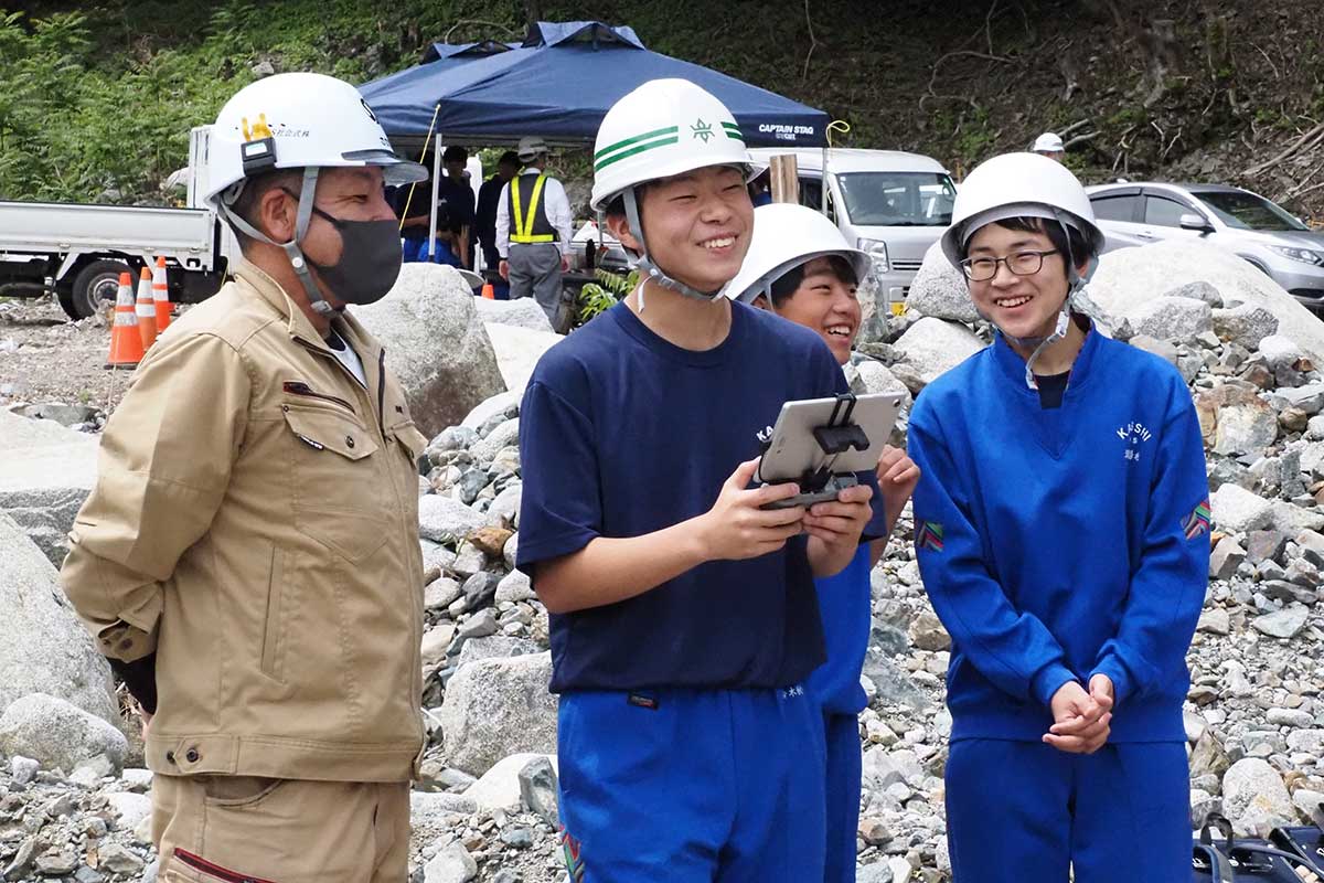 工事関係者と触れ合い笑顔を見せる生徒たち