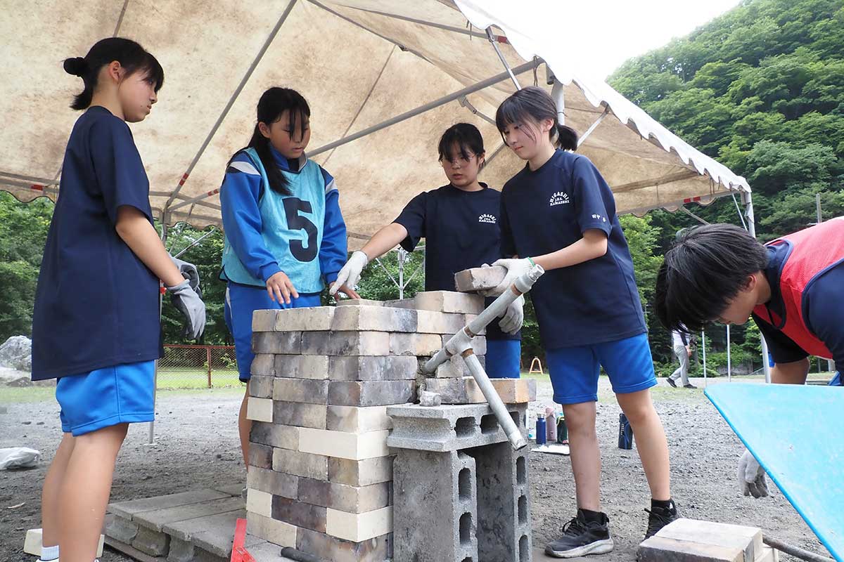 仲間と協力して炉造りに取り組む釜石東中の1年生＝2日