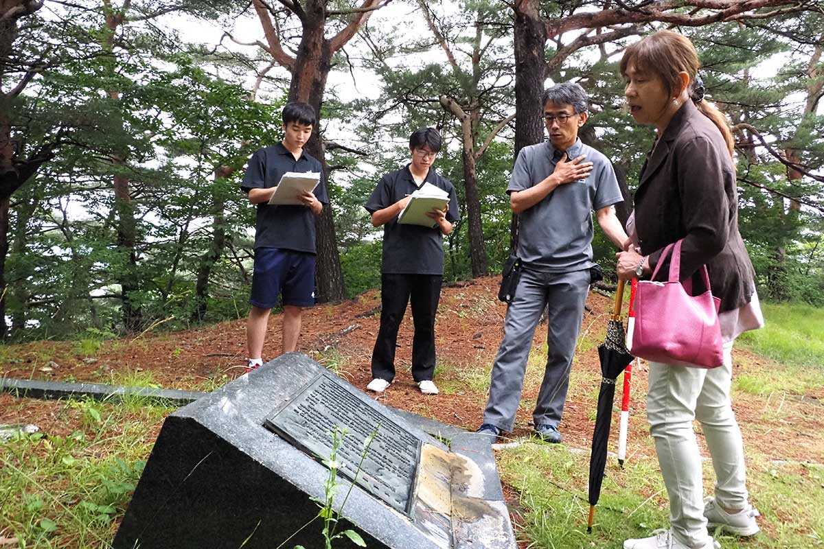 千葉まき子さん（右）の説明を聞く生徒ら＝7月10日、大平町