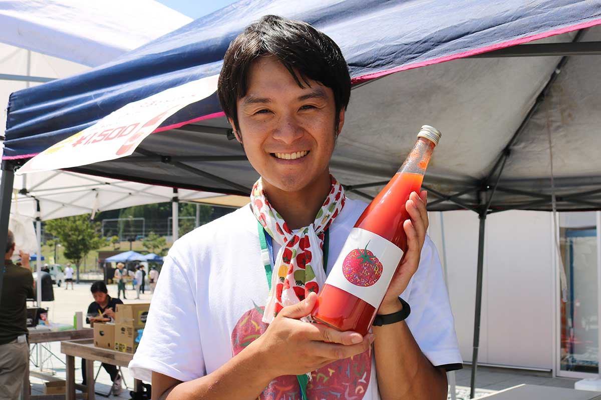 「すずこま」が原料のトマトジュースを販売した三科宏輔さん