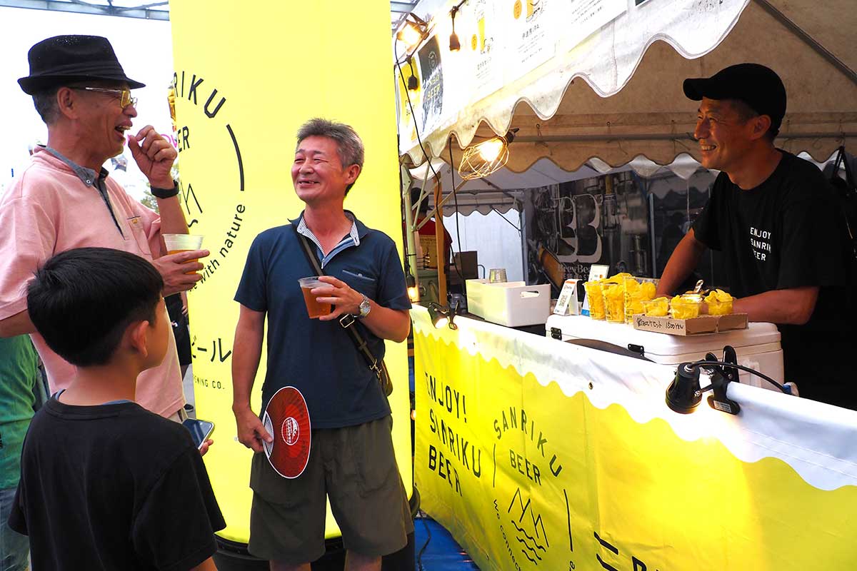 ビールを片手に談笑する来場者と出店者