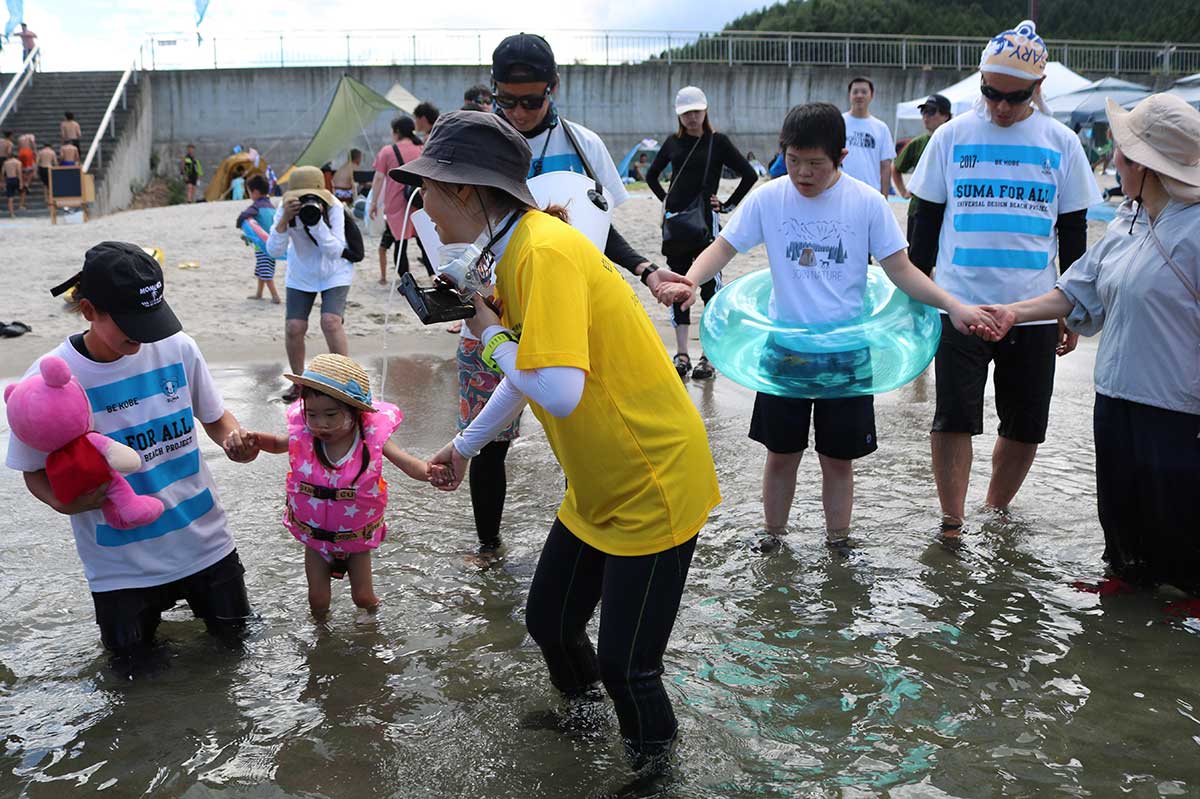 NPO法人須磨ユニバーサルビーチプロジェクト(神戸市)のメンバー(水色しまTシャツ)らが子どもたちをサポート