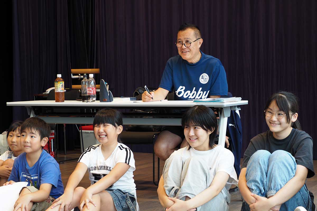 ボビー中西さん（奥）を講師に楽しく学ぶ生徒たち