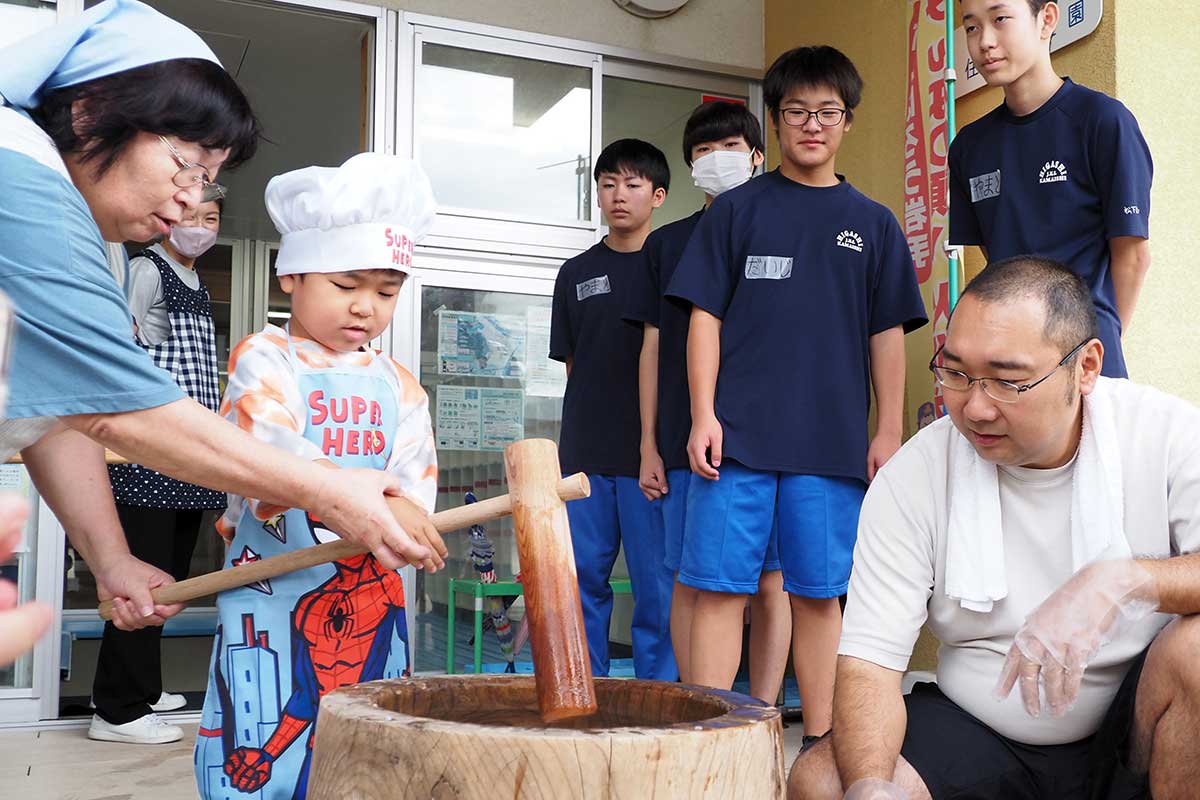園児は中学生や大人たちの力を借りて餅つきに挑戦した
