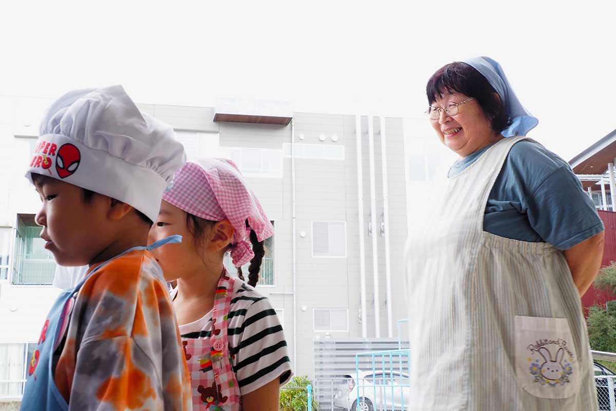 体験活動を楽しむ園児をうれしそうに見守る磯田育子園長