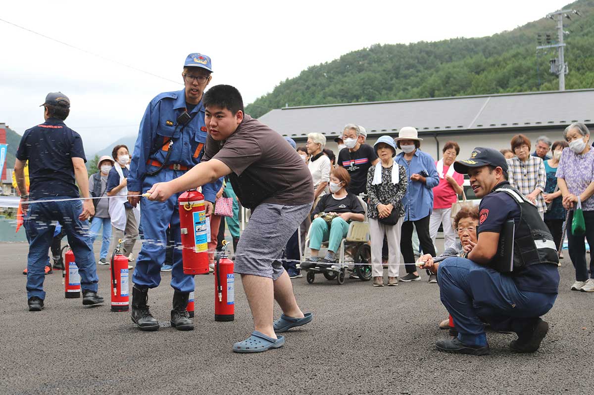 消防署員、団員らの指導で消火器(訓練用)の操作も体験した