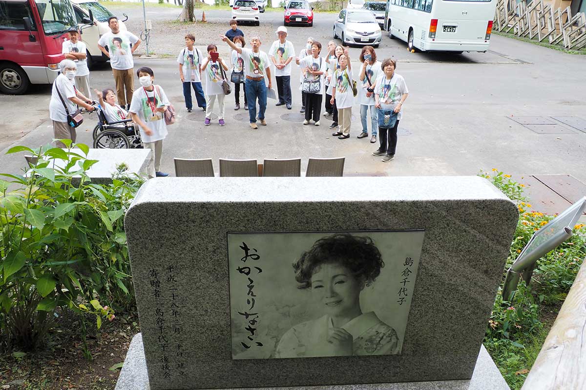 避難路の入り口から優しいまなざしの島倉さんが海岸を見守る