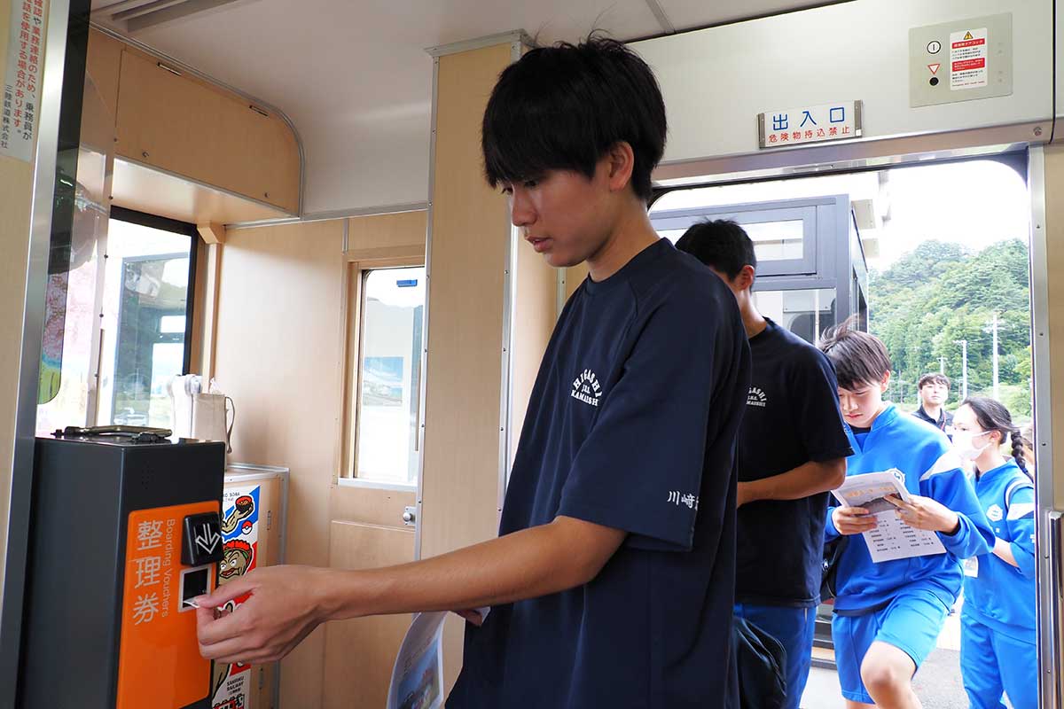 車両に乗り込む生徒ら。「整理券を取るのを忘れずに！」
