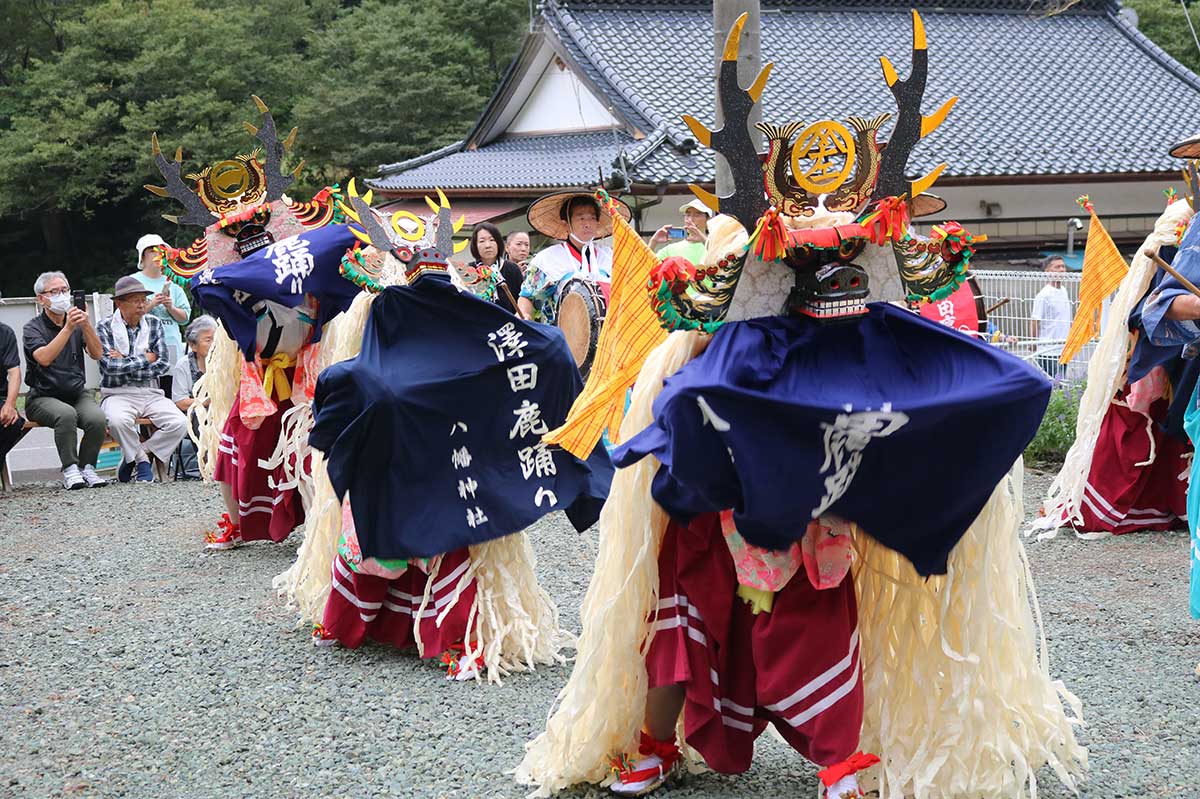 住民らが見守る中、伝統の舞を披露する鹿踊の踊り手