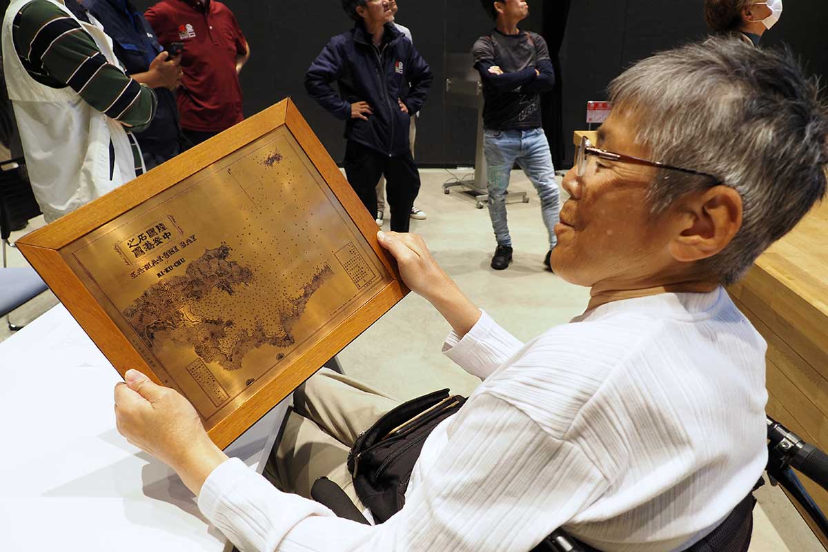村上さんが入手した海図の銅版レプリカに触れる参加者
