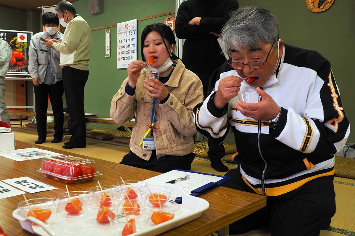 一口大に切った柿を試食し甘さや食感を確かめた