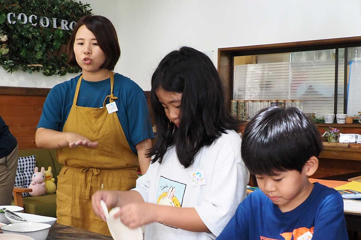 ピザの作り方を伝える石塚佳那子代表(左)