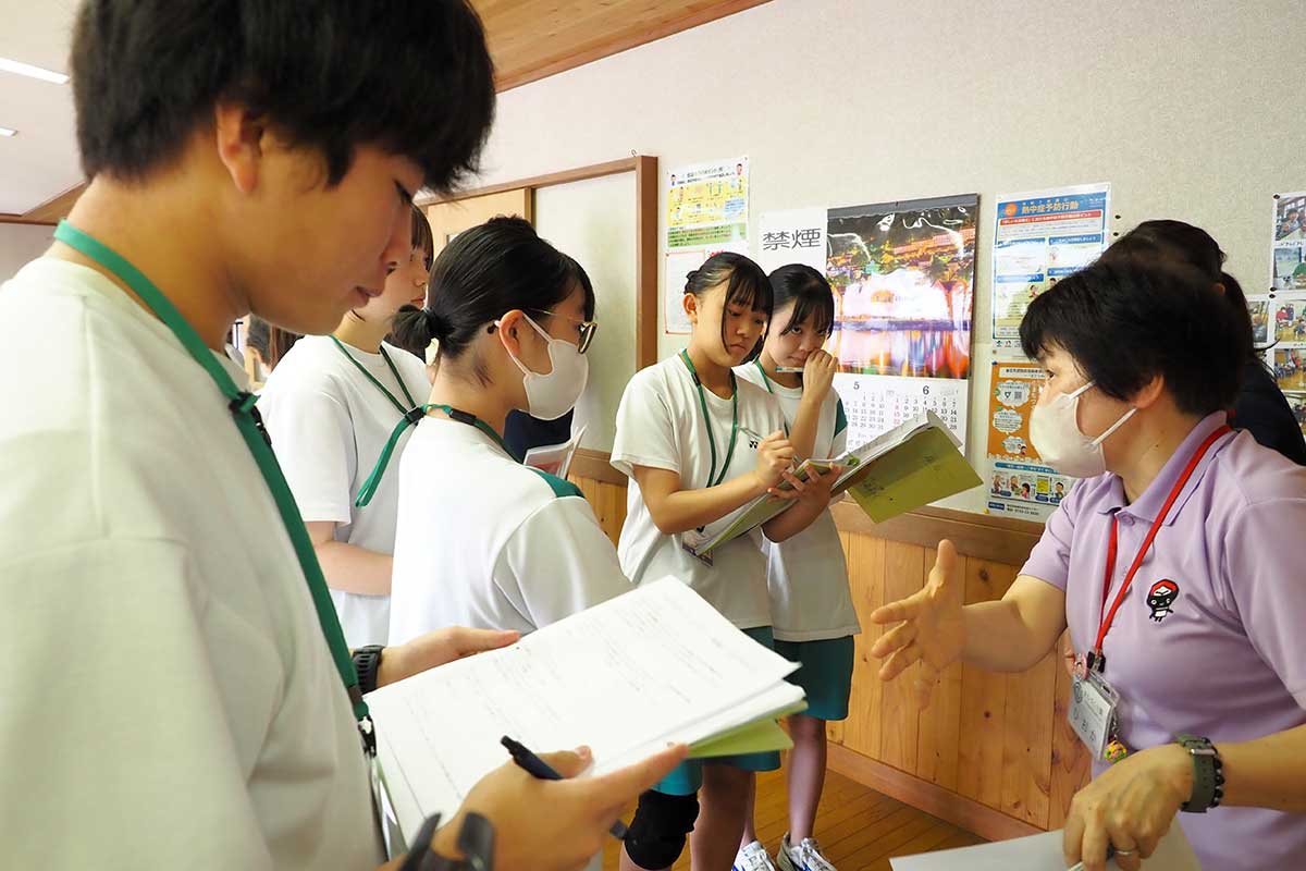 助言を受けつつカフェの準備をする中学生=2025年6月30日