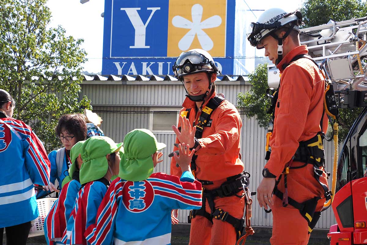 子どもたちとの交流に頬を緩める消防署員