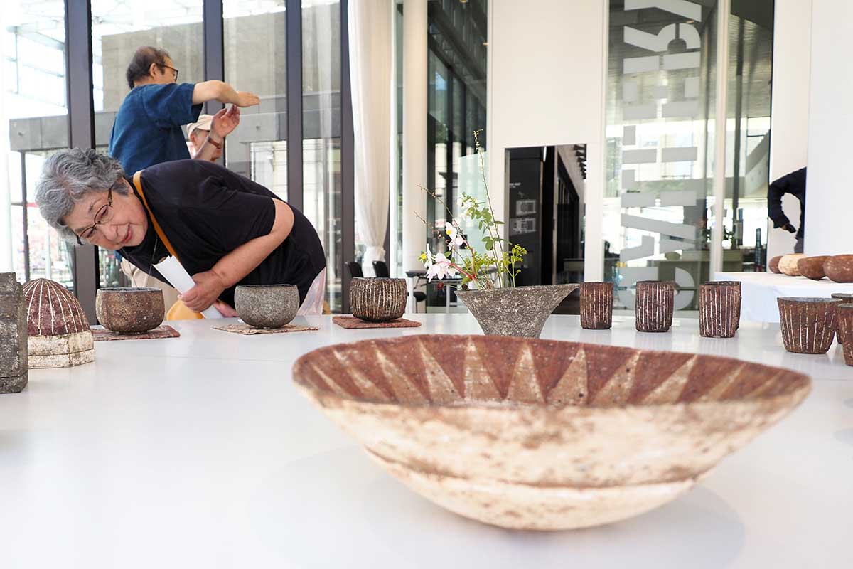 顔を寄せ作品にじっくり見入る来場者