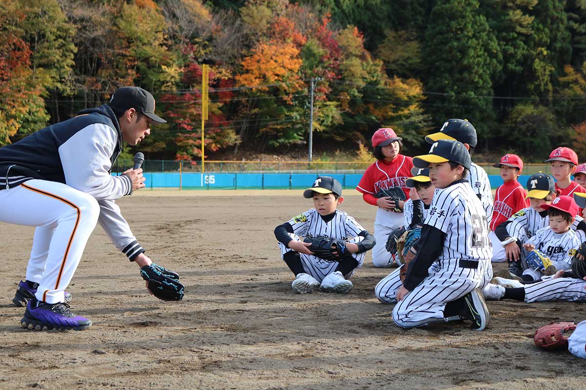 大田さん(左)から捕球の仕方を学ぶ。基礎習得の重要性も伝えられた