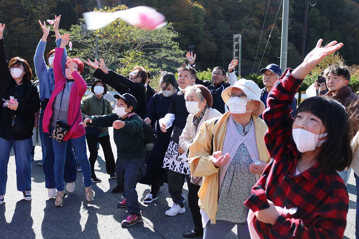 宙を舞う紅白餅。ダイレクトキャッチも? 手前の女の子は洋服の前見頃を袋代わりに…