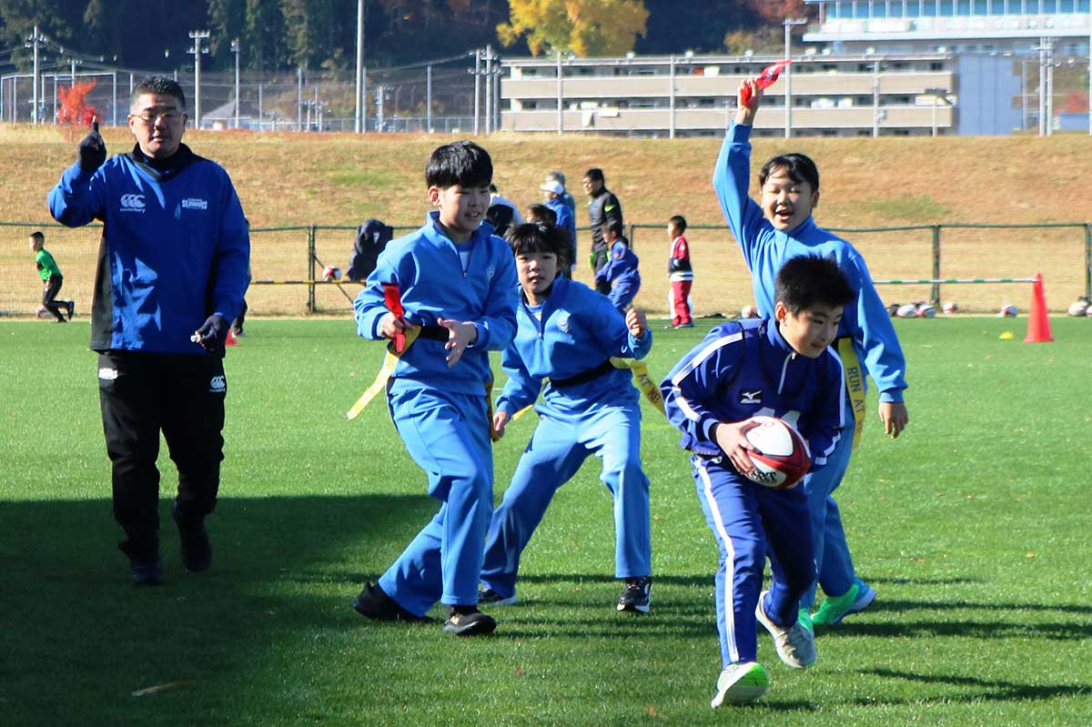 平田ブルースターの選手のタグを取り高く掲げる鵜住居エタニティーズの選手（予選Aブロック）