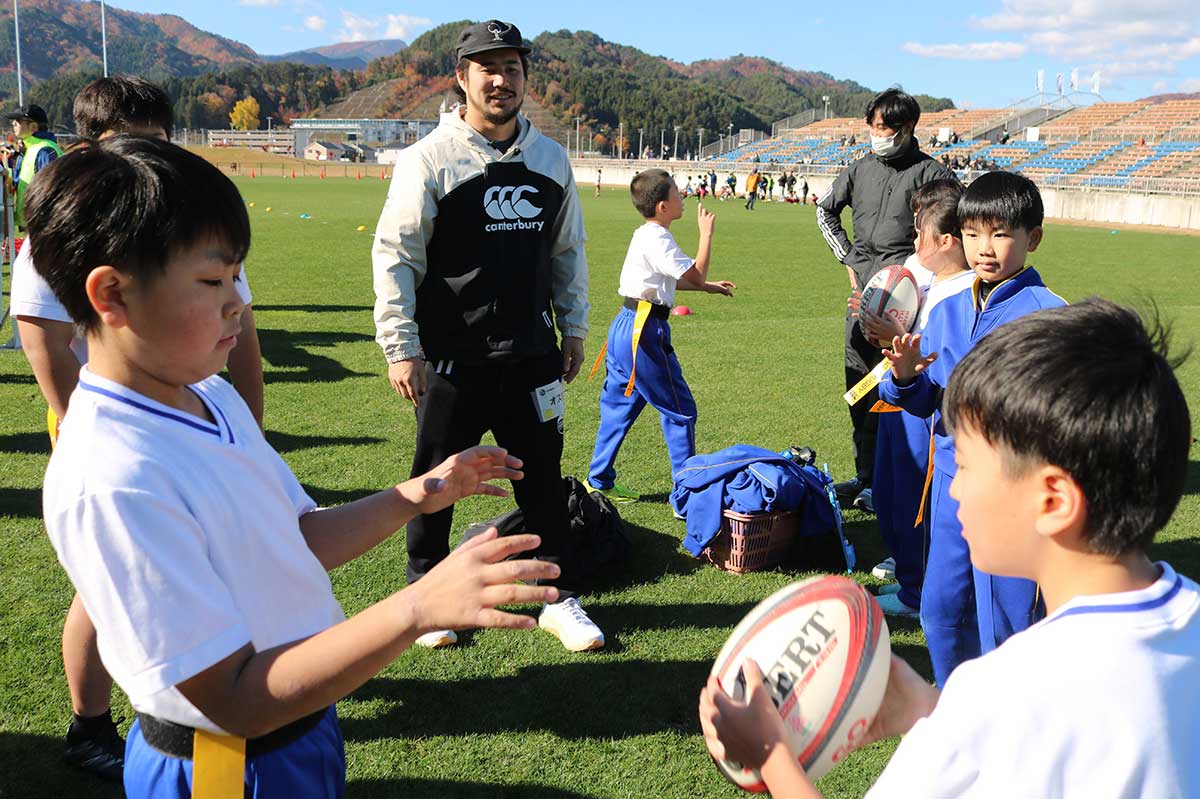 SWの村田オスカロイド選手のアドバイスを受けながらパス練習する小佐野小生