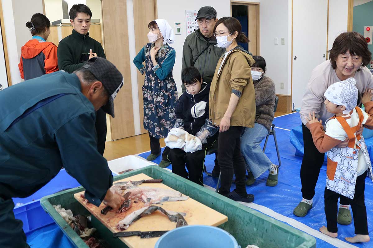 地元漁師が魚のさばき方を実演。プロの手際に興味津々