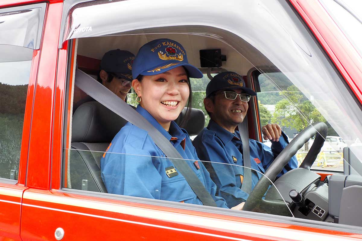 消防車両の運転席から顔をのぞかせる小林真由美さん。消防団に入団し3年目となる=10月