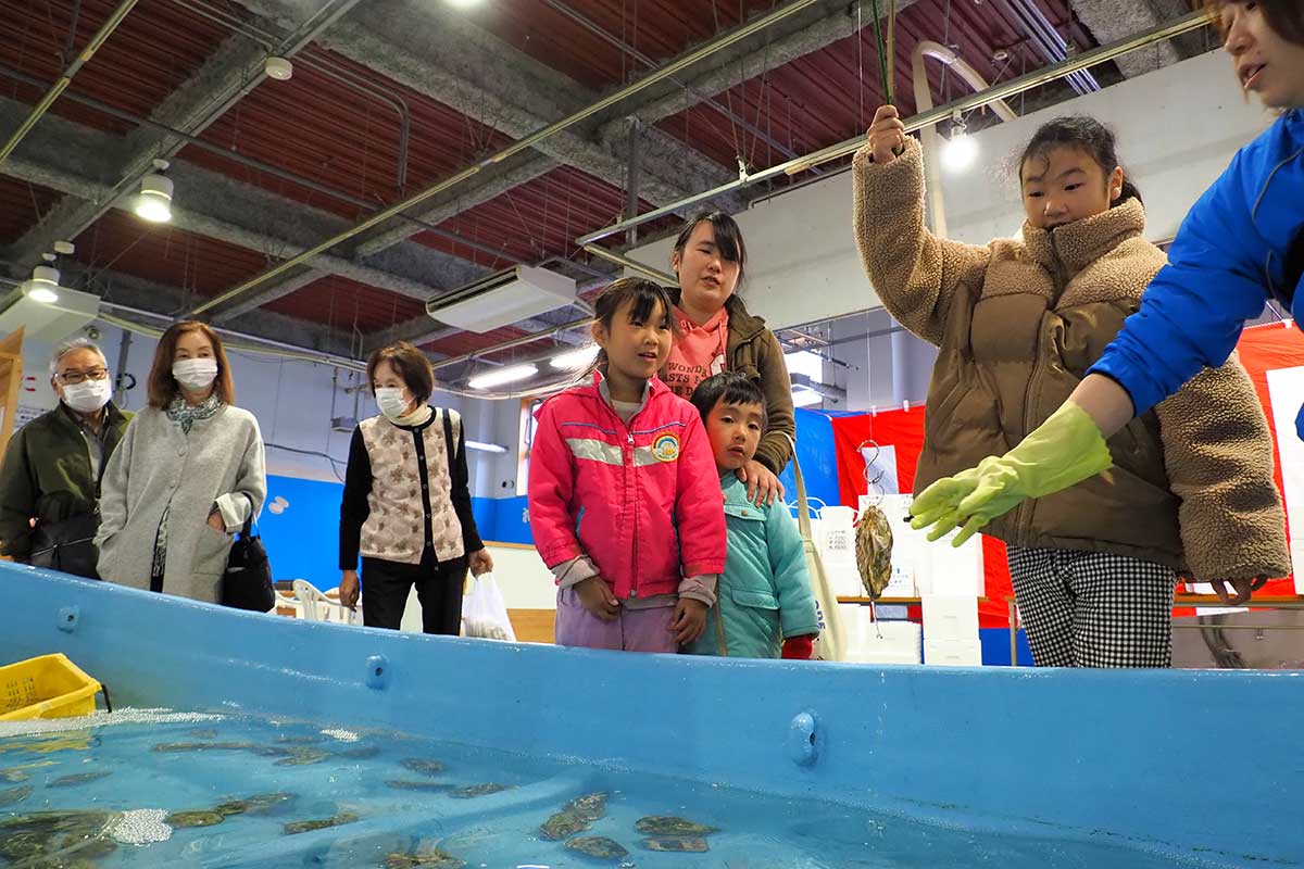 カキに狙いを定める家族連れ。「やったー、釣れた！」