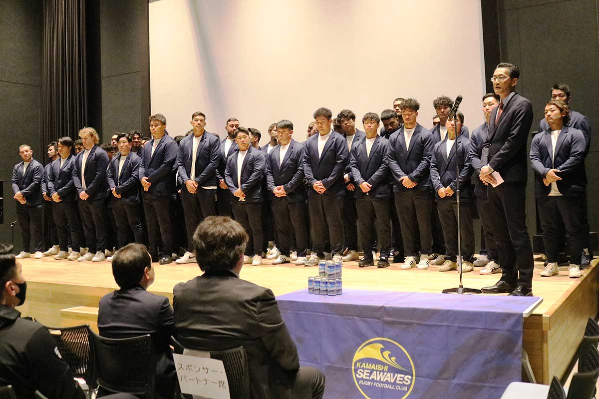 日本製鉄北日本製鉄所の高瀬賢二副所長(壇上前列右)から激励の言葉を受け、気を引き締める選手ら