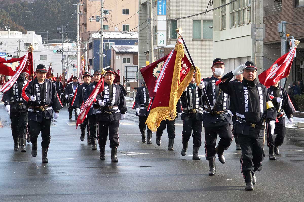 消防出初式で分列行進する釜石市消防団の団員ら=12日、大町目抜き通り