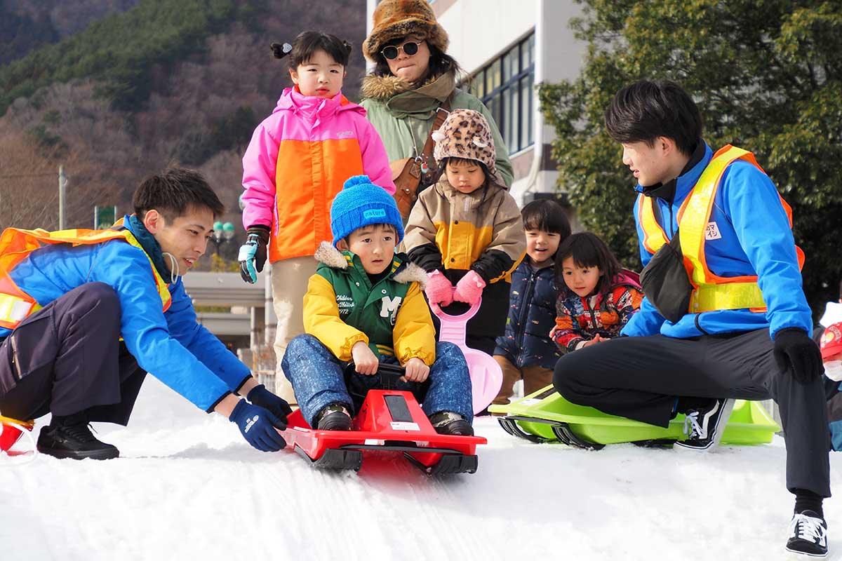 街なかに出現した雪の滑り台で遊ぶ子どもたち＝10日