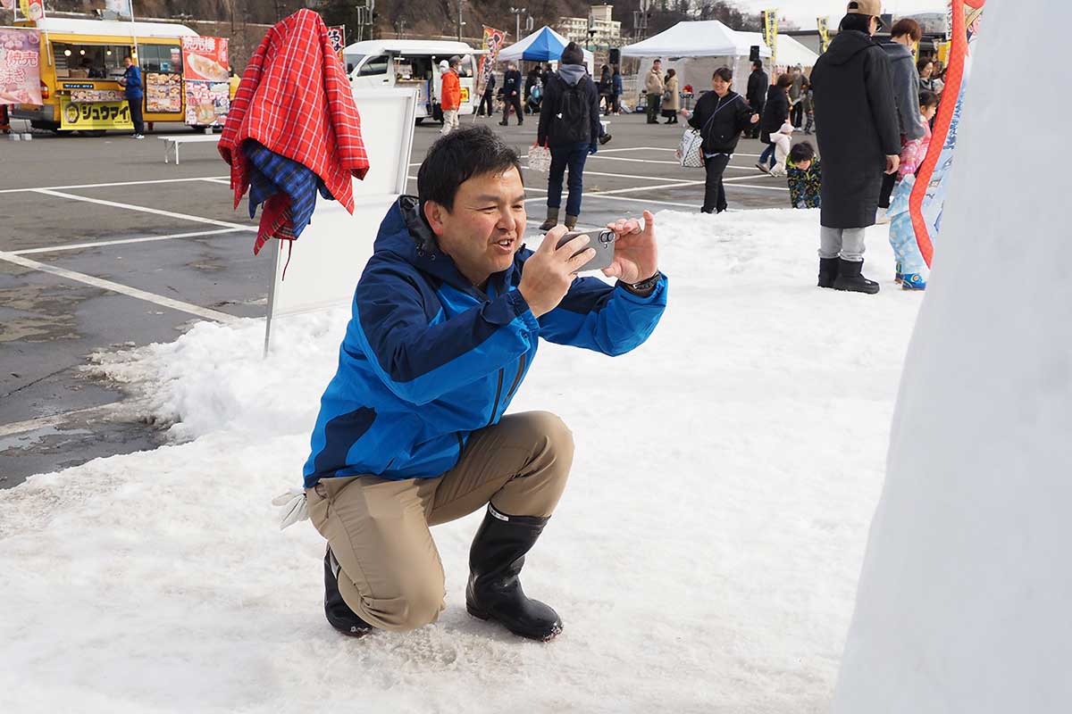 かまくら体験で撮影サービスに応じた横手市の佐藤健一郎さん