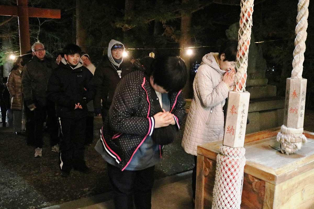 新しい年への願いを込め、神前に手を合わせる参拝客＝八雲神社、元日午前0時すぎ