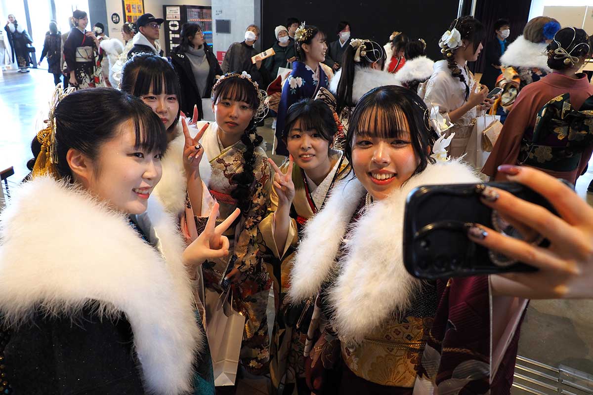 スマホ片手にパチリ。再会した友人と記念撮影を楽しむ