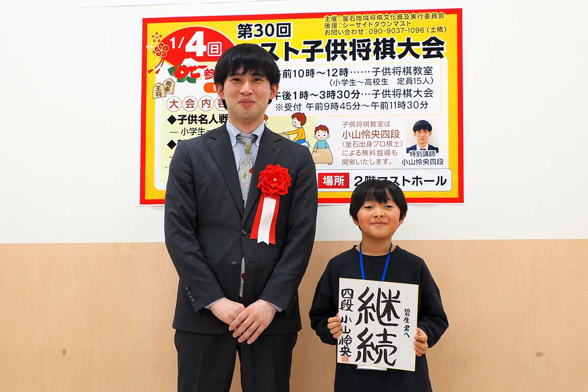 憧れの小山四段に色紙を書いてもらい笑顔を見せる子ども