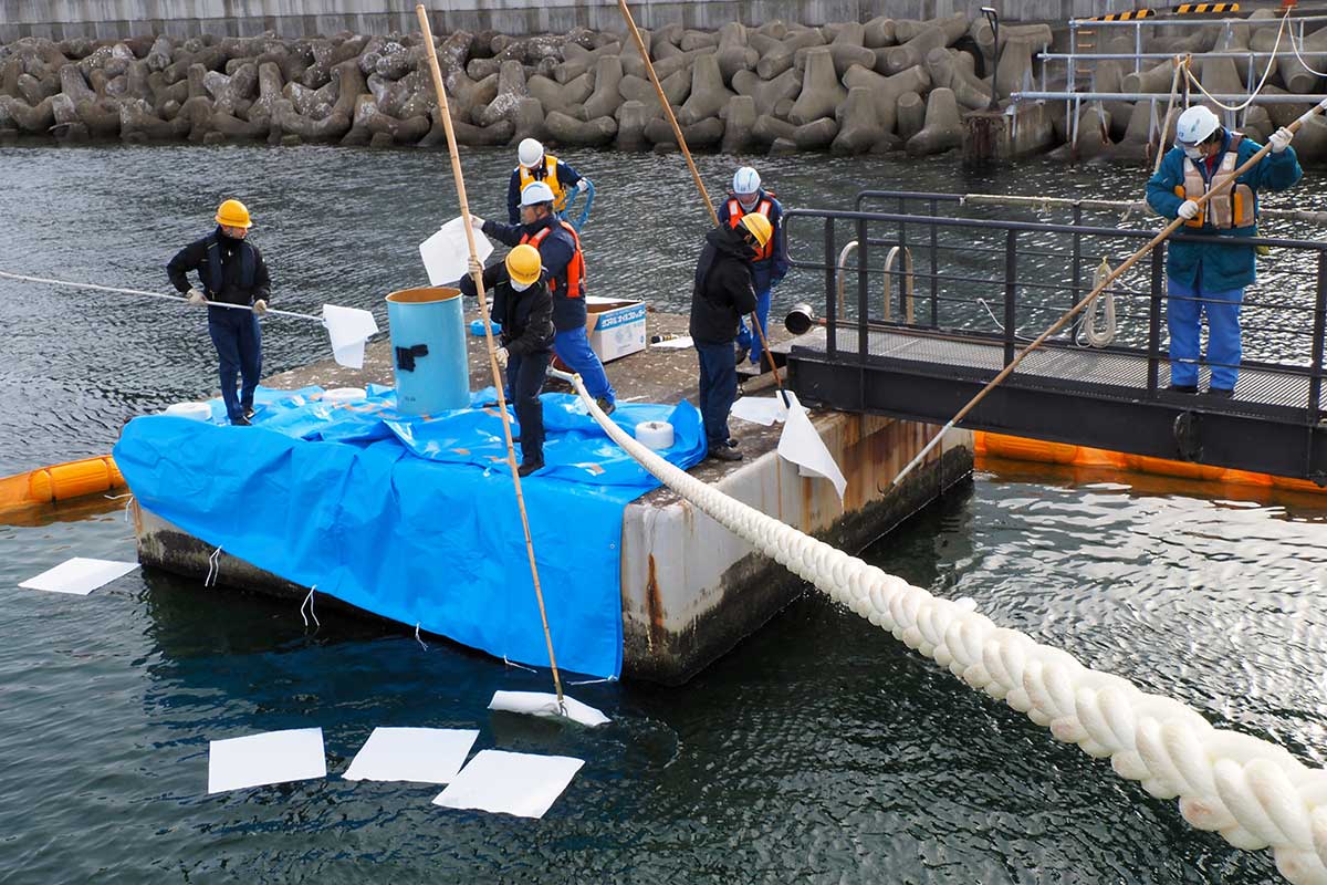 油の流出を想定した訓練で防除の手法を確認する参加者