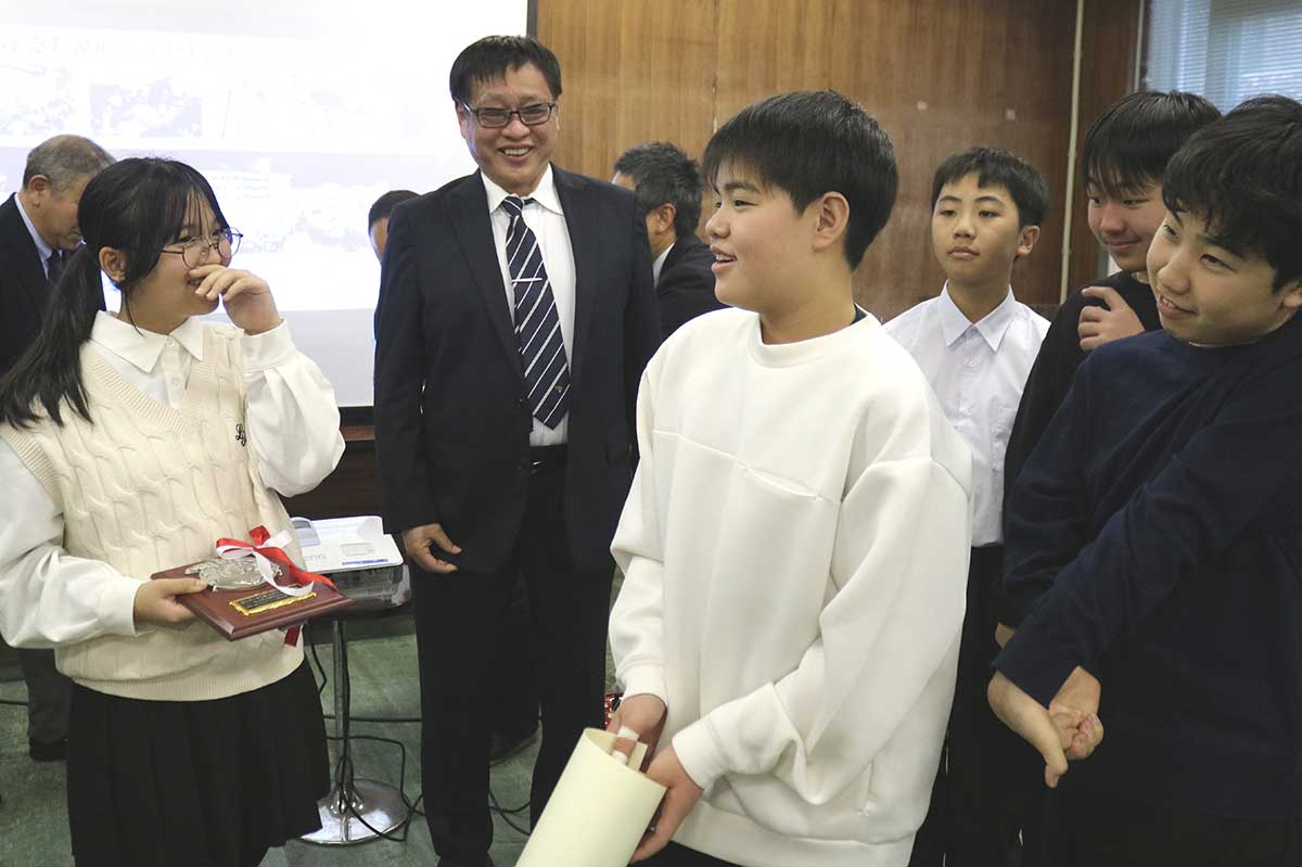 髙橋勝教育長に優秀賞の賞状や盾を見せながら受賞を報告する児童