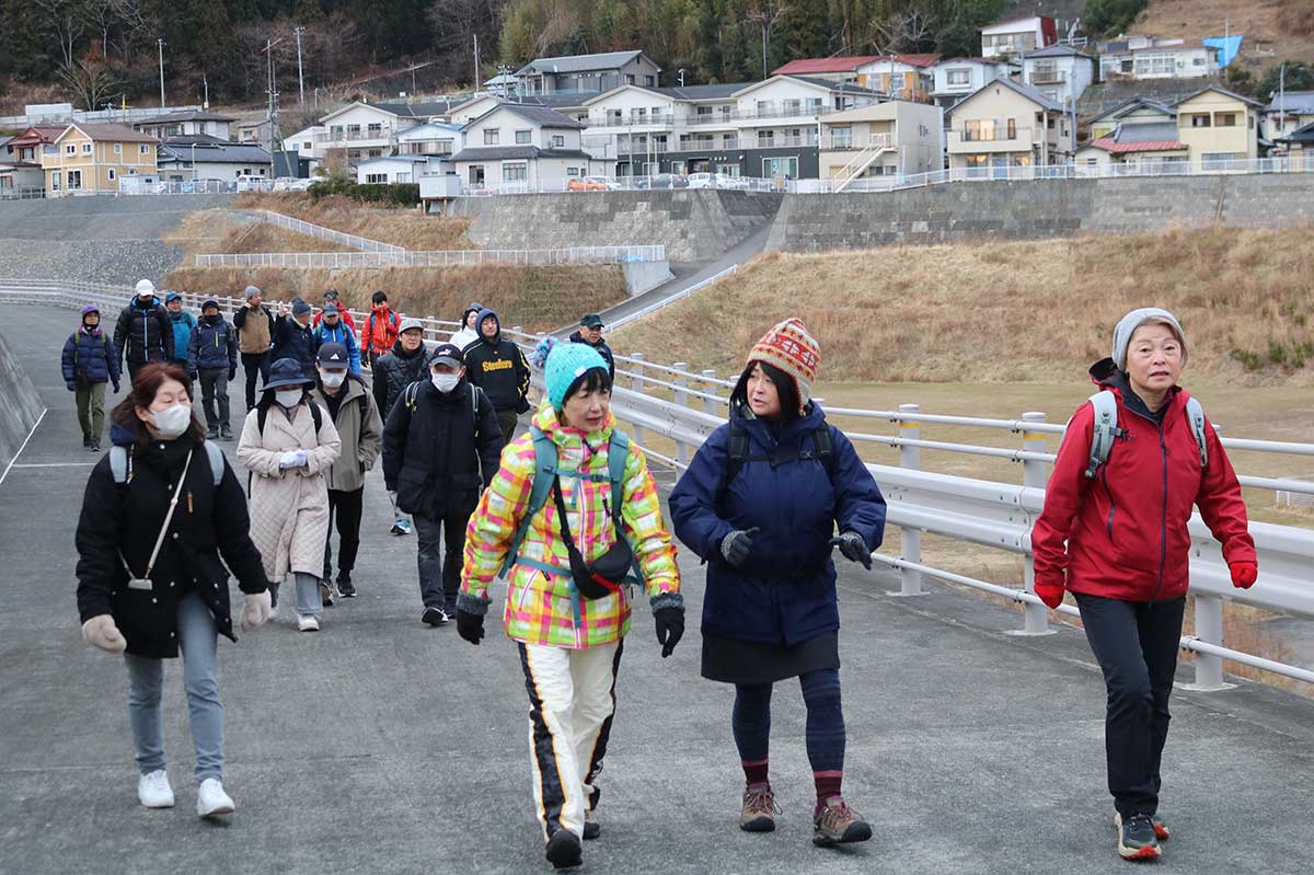 小白浜漁港の防潮堤内側を歩く。進行方向左手の高台には民家が並ぶ