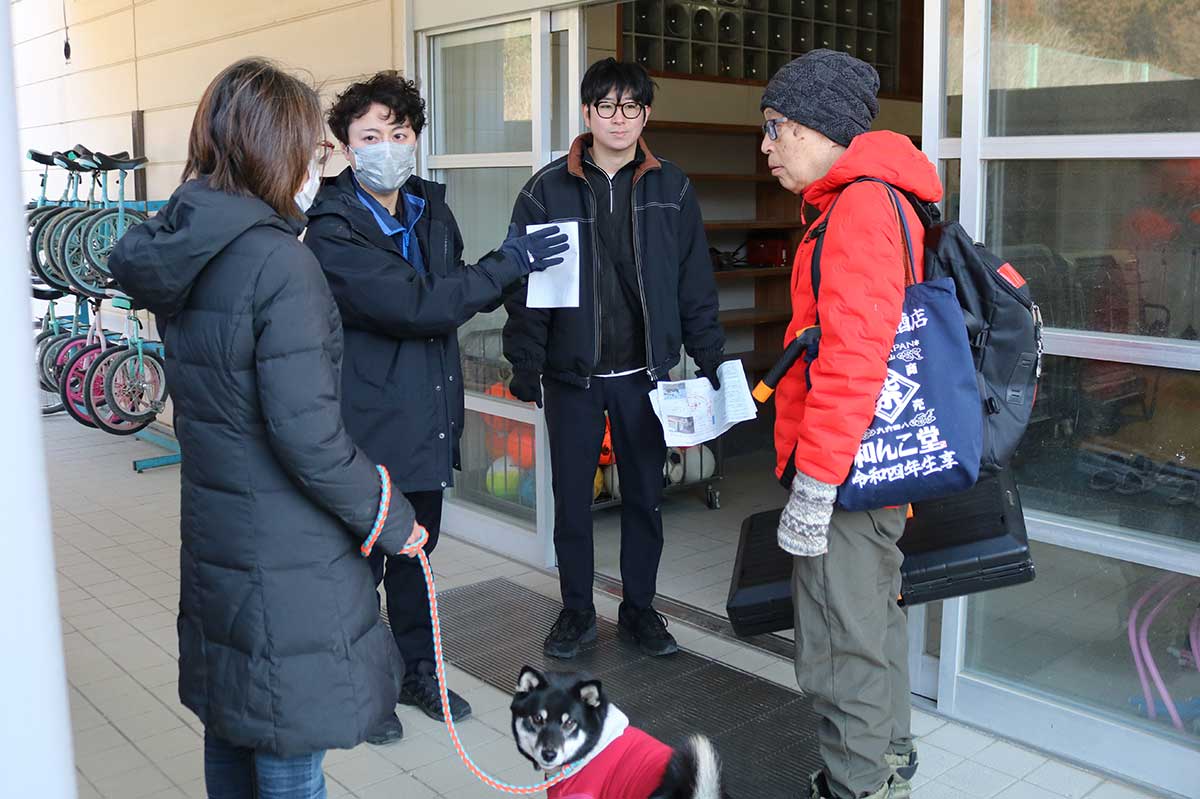 避難者の居住スペースとなる体育館の前で「同行避難」について説明を受ける