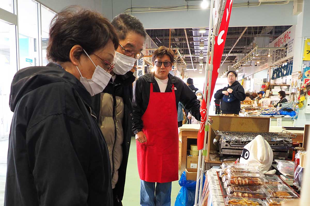 肉厚でプリプリ食感を楽しめるイカ焼きを並べた実行委員長の平野嘉隆さん(左から3人目)